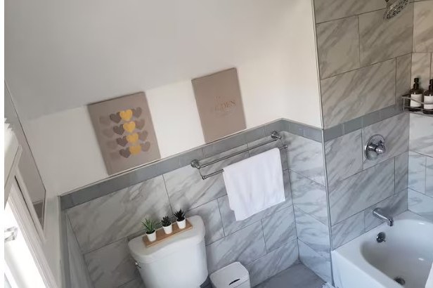 Tiled bathroom with tub and shower